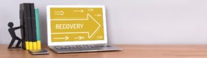 A laptop with the word "Recovery" on the screen